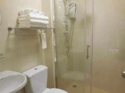 a bathroom with a shower and a toilet and towels at Guest House, shared pool, private bathroom and kitchen in Phuket Town