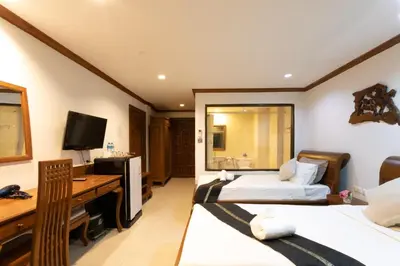 a hotel room with two beds and a desk at Best Venue Hotel in Patong Beach