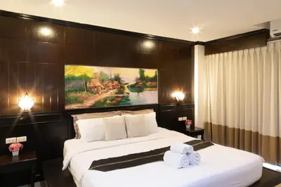 a hotel room with a large bed with two towels at Best Venue Hotel in Patong Beach