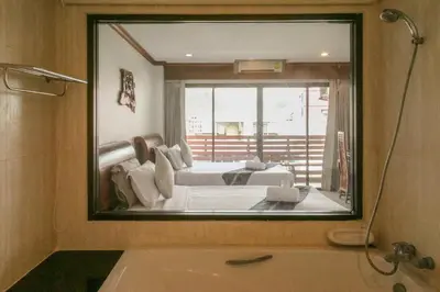 a mirror in a bathroom with a bed and a tub at Best Venue Hotel in Patong Beach