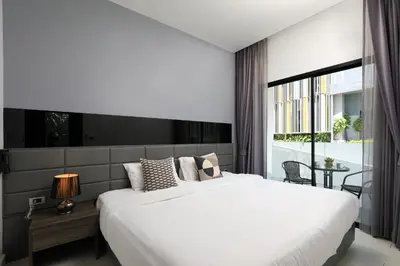 a bedroom with a large white bed and a window at 1 bdr apartment in Utopia Naiharn by Capital pro in Phuket Town