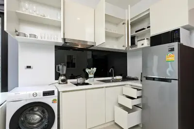 a kitchen with white cabinets and a washer at 1 bdr apartment in Utopia Naiharn by Capital pro in Phuket Town