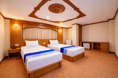 a hotel room with two beds and a tv at Tiger Complex Hotel in Patong Beach