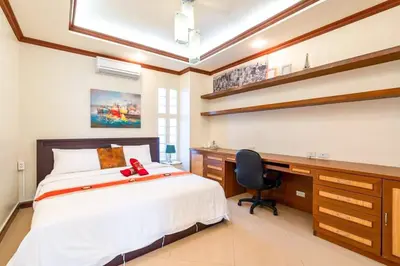 a bedroom with a bed and a desk and a chair at Poolvillapanwa in Panwa Beach