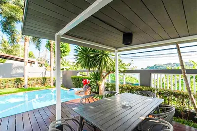 a patio with a table and chairs next to a swimming pool at Poolvillapanwa in Panwa Beach