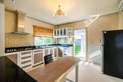 a large kitchen with a wooden counter top and a refrigerator at Poolvillapanwa in Panwa Beach
