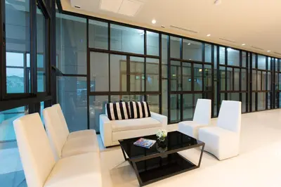 a living room with white chairs and a table at Sugar Palm Residence in Phuket Town