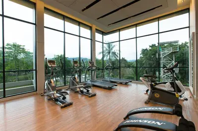 a gym with a row of treadmills and ellipticals at Sugar Palm Residence in Phuket Town