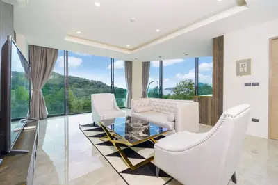 a living room with white chairs and a glass table at Scenic Seaview 270 Panorama, 2BR Penthouse VV Patong C701 in Patong Beach