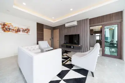 a living room with two white chairs and a television at Scenic Seaview 270 Panorama, 2BR Penthouse VV Patong C701 in Patong Beach