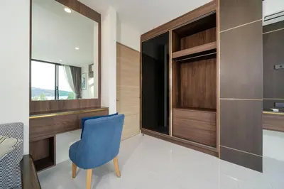 a bedroom with a blue chair and a mirror at Scenic Seaview 270 Panorama, 2BR Penthouse VV Patong C701 in Patong Beach