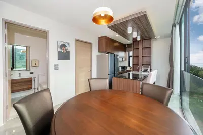 a kitchen and dining room with a wooden table and chairs at Scenic Seaview 270 Panorama, 2BR Penthouse VV Patong C701 in Patong Beach