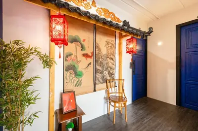 a room with a painting on the wall and a chair at Marco Polo Phuket Poshtel & Bistro in Phuket Town