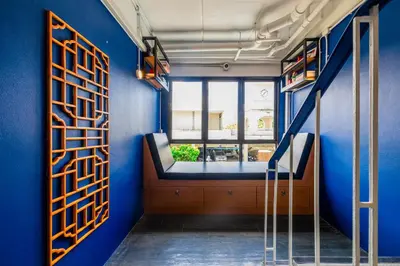 a room with a blue wall and a window at Marco Polo Phuket Poshtel & Bistro in Phuket Town