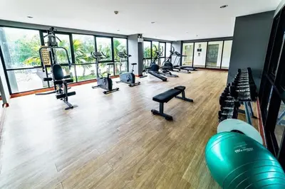a gym with a row of treadmills and machines at Cozy 1 bedroom in prime Bangtao in Bang Tao Beach