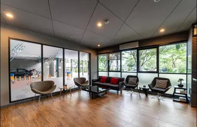 a large room with chairs and tables and windows at Cozy 1 bedroom in prime Bangtao in Bang Tao Beach