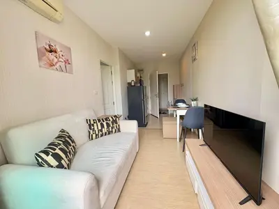 a living room with a white couch and a kitchen at Cozy 1 bedroom in prime Bangtao in Bang Tao Beach