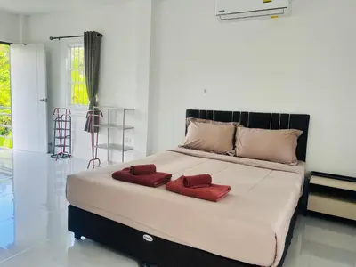 a bedroom with a large bed with red pillows on it at Rest Mind House in Surin Beach