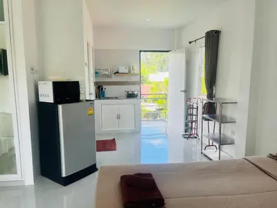 a white kitchen with a refrigerator and a counter top at Rest Mind House in Surin Beach