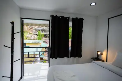 a bedroom with a bed and a large window at The Bright House, Koh Phi Phi in Phi Phi Don