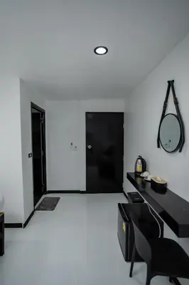 a living room with a black desk and a mirror at The Bright House, Koh Phi Phi in Phi Phi Don