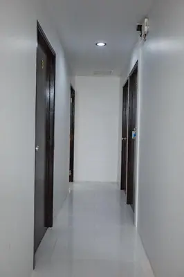 a hallway with two doors and a white wall at The Bright House, Koh Phi Phi in Phi Phi Don