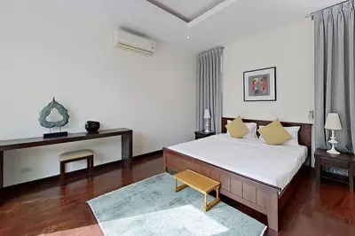 a bedroom with a large bed and a table at Mandala by Villacarte in Bang Tao Beach