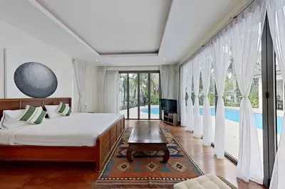 a bedroom with a bed and a swimming pool at Mandala by Villacarte in Bang Tao Beach