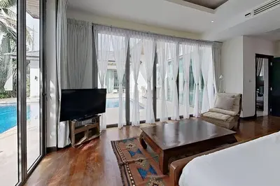 a bedroom with a bed and a tv and a couch at Mandala by Villacarte in Bang Tao Beach
