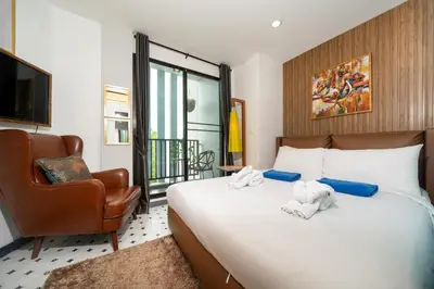 a bedroom with a bed with a chair and a television at Zcape1 apartment at Boat Avenue by Lofty in Bang Tao Beach