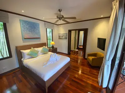a bedroom with a bed with a ceiling fan at Luxury Sai Taan Villa in Bang Tao in Bang Tao Beach