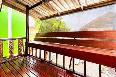 a wooden bench on a balcony with a window at Lamsai AC Sea House in Ko Yao Noi