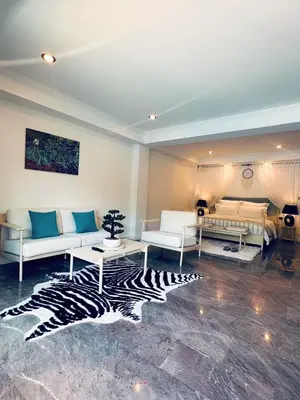a living room with two white couches and a zebra rug at Ocean Pie Phuket - Adult Only in Rawai Beach