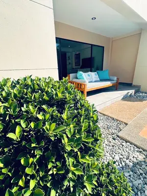a bush in front of a house with a couch at Ocean Pie Phuket - Adult Only in Rawai Beach