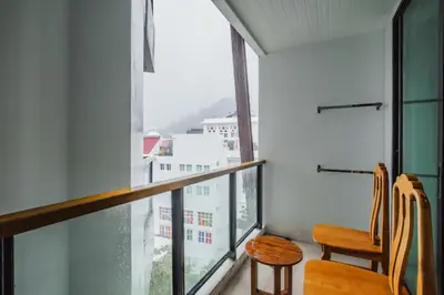 a room with two chairs and a large window at The Lunar Patong in Patong Beach