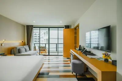 a hotel room with a bed and a desk at The Lunar Patong in Patong Beach