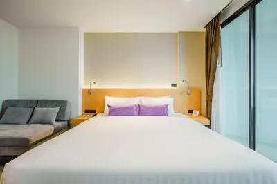 a bedroom with a large bed and a couch at The Lunar Patong in Patong Beach