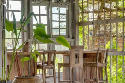 a room with two chairs and a table and a plant at Artisan koh yao yai handcraft beachfront villas. in Ban Lo Pa Ret