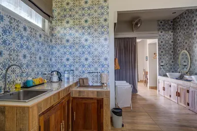 a kitchen with a sink and blue wallpaper at Artisan koh yao yai handcraft beachfront villas. in Ban Lo Pa Ret