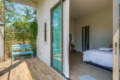 a bedroom with a bed and a sliding glass door at Artisan koh yao yai handcraft beachfront villas. in Ban Lo Pa Ret