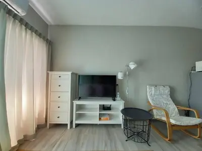 a living room with a tv and a chair at B6 НОВАЯ на БАССЕЙН ВАТСАП669З582I976 in Nai Yang Beach
