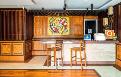 a bar with two chairs and a painting on the wall at Rudi Condo by Q Conzept in Kata Beach