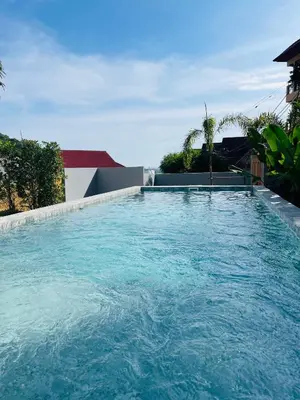 a large swimming pool in the middle of a house at Baan Saint-Tropez Seaview Villas Kata Beach in Kata Beach