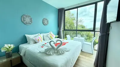 a bedroom with a bed with two swans on it at Baan Saint-Tropez Seaview Villas Kata Beach in Kata Beach
