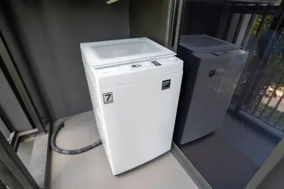 a small white refrigerator next to a trash can at Apartment in laguna , 600 metres from the beach in Phuket Town