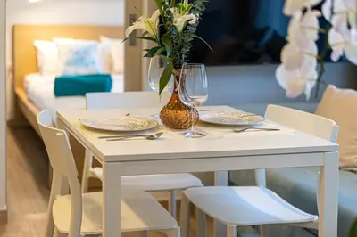 a white table with chairs and a vase with flowers at Apartment in laguna , 600 metres from the beach in Phuket Town