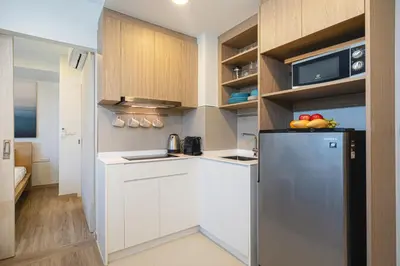 a kitchen with white cabinets and a refrigerator at Apartment in laguna , 600 metres from the beach in Phuket Town