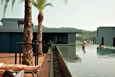 a pool with palm trees and people in the water at City Gate Kamala D209 by Phuket Sabay Rent in Phuket Town