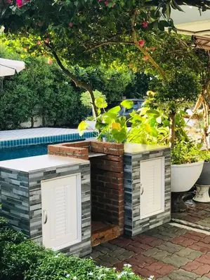 a garden with a swimming pool and some plants at Summer House,shared pool, private bathroom and kitchen in Ban Phlu Yai