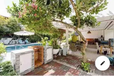 a house with a swimming pool and a tree at Summer House,shared pool, private bathroom and kitchen in Ban Phlu Yai